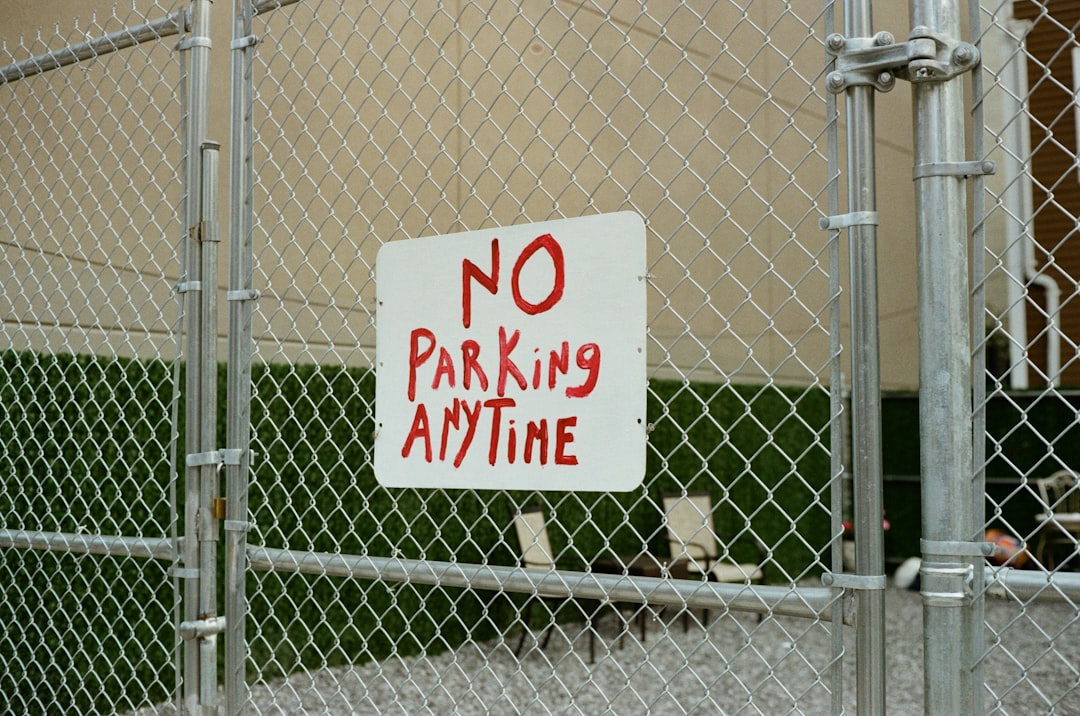 a-no-parking-sign-on-a-chain-link-fence-1g-wt-9buv8